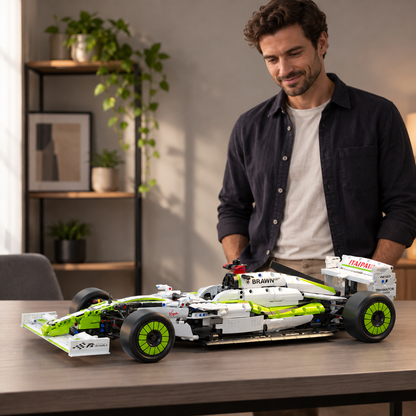 Pessoa adulta atrás de um carro de blocos verde e branco apoiado sobre uma mesa, em vista lateral.